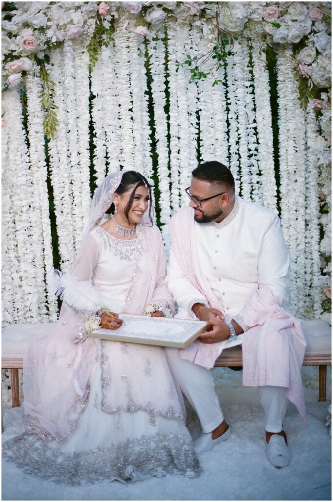 A Pakistani Muslim couple during their outdoor nikkah ceremony at the Bella Gardens in King City, captured on film with soft light and timeless, emotional wedding photography.