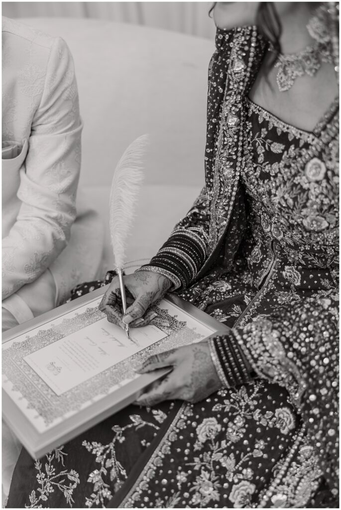 Pakistani bride signing her nikkah papers at wedding in Indiana