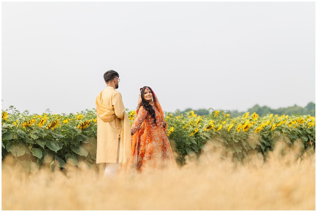 A couple posing in a sunflower field for their pakistani mehendi in oakville